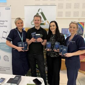 Members of staff holding electronic devices at the digital donation event